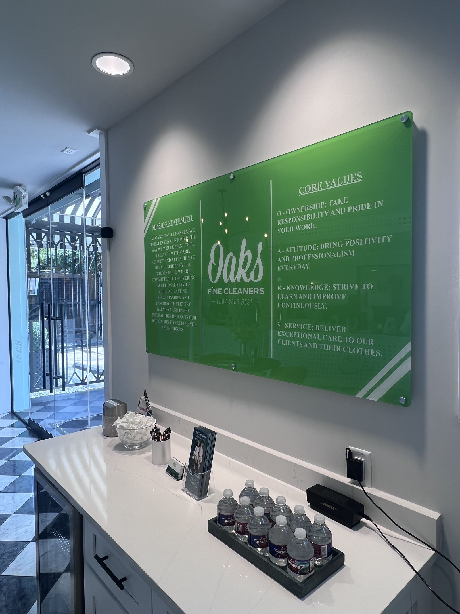Green acrylic information board mounted behind a counter