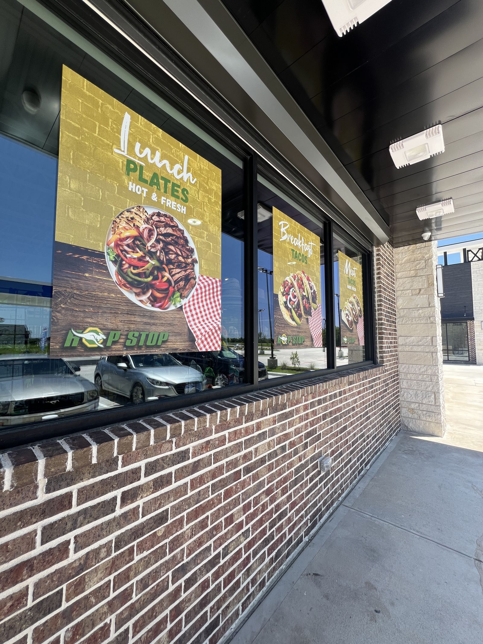Exterior menu display boards mounted on a brick restaurant wall